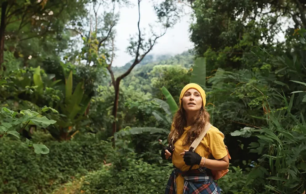 Eine Frau mit einem Rucksack stehe im Dschungel