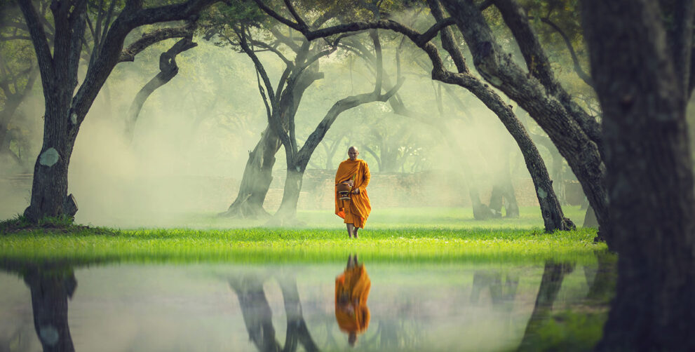 Mönch läuft durch einen Wald in Thailand