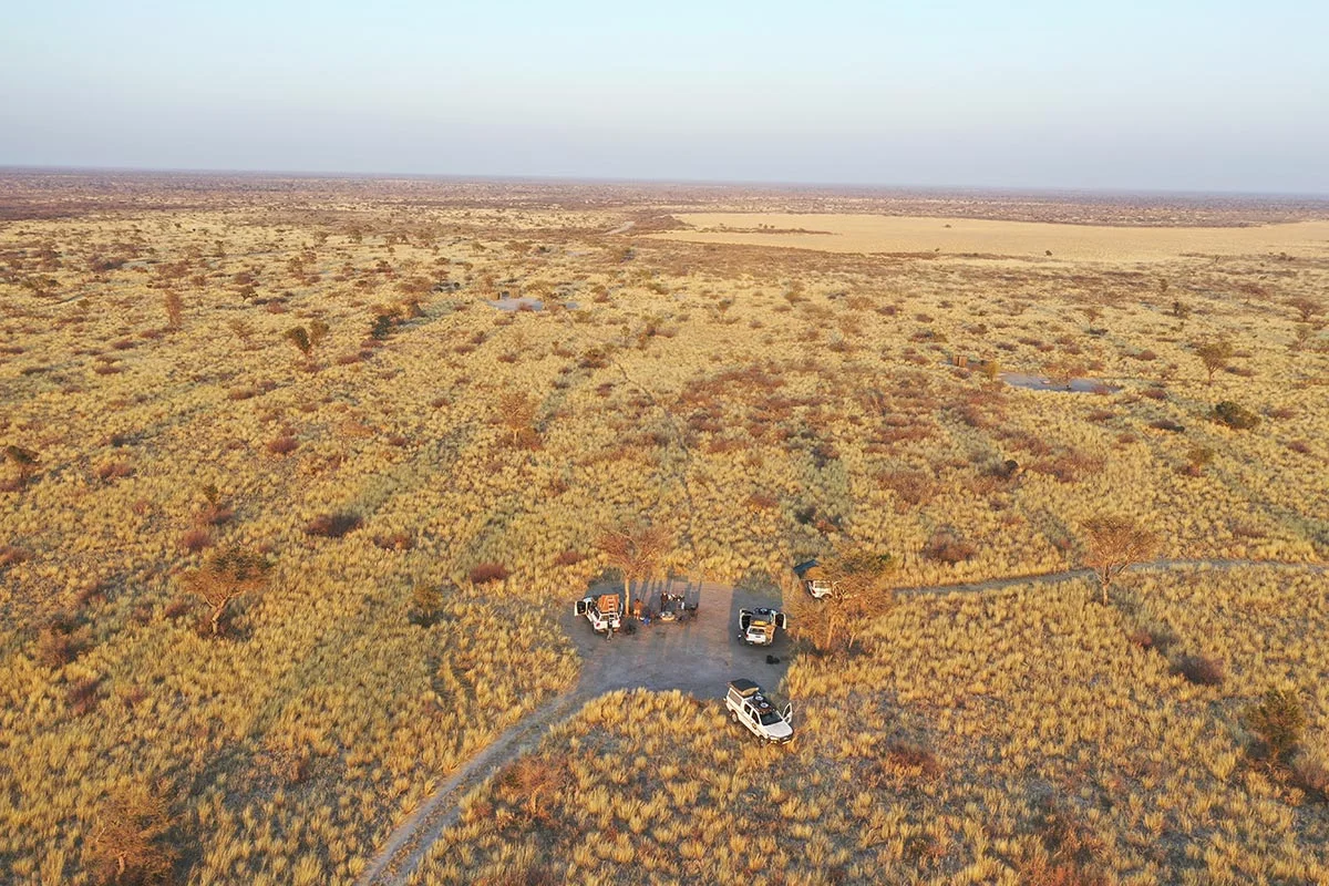 Trockene Landschaft mit Autos im Khutse Game Reserve.