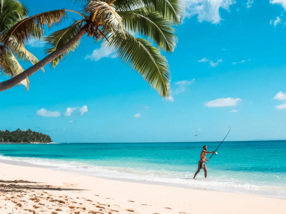 Fischer am tropischen Strand unter Palmen vor blauem Himmel am Meer. Ideal für Urlaub, Entspannung und Naturerlebnis.